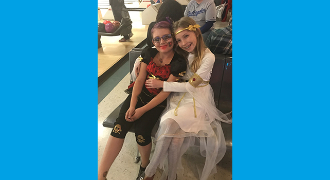 Two girls at a bowling ally in costumes