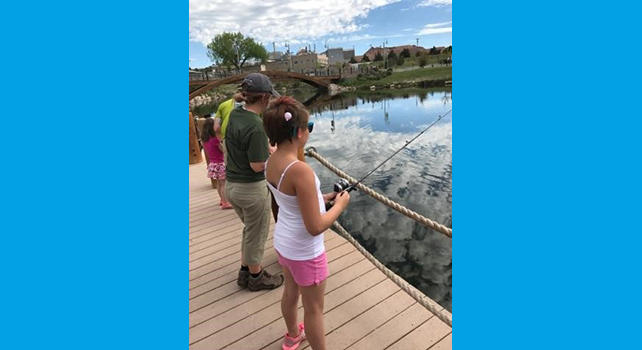 A group of children fishing at a pond